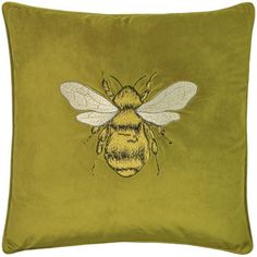 a green pillow with a bee embroidered on it