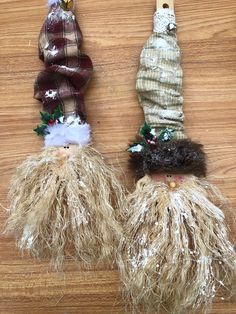 two dolls made out of straw sitting on top of a wooden table