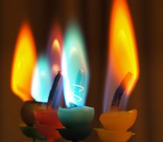 three candles with different colored lights on them