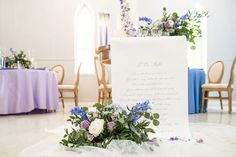 a bouquet of flowers sits on the floor next to a sign