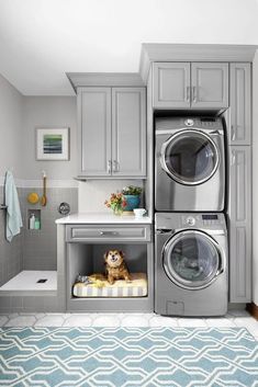 a washer and dryer in a small room with blue rug on the floor