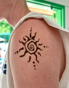 a man with a sun tattoo on his arm