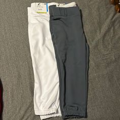 two men's pants laying on top of a bed