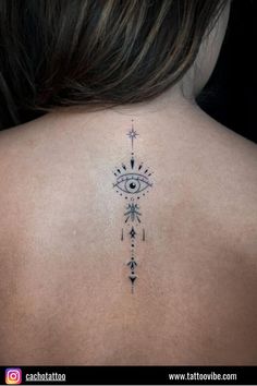 the back of a woman's neck with an all seeing eye tattoo