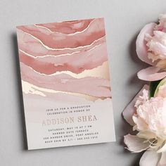 a pink and gold wedding card with peonies on the side next to it