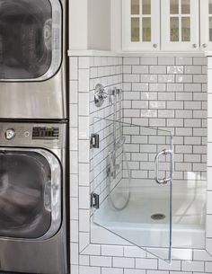 a washer and dryer sitting next to each other in a room with white cabinets