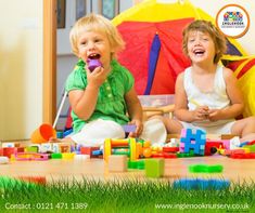 two young children sitting on the floor playing with building blocks and toys in front of them