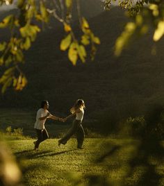 two people are holding hands in the grass