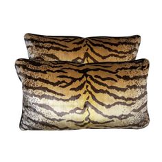 two zebra print pillows sitting on top of each other in front of a white background