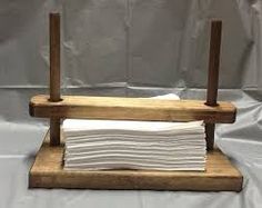 a stack of white napkins sitting on top of a wooden stand