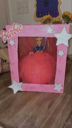 a barbie doll in a pink frame with white stars on the bottom and an orange ball inside