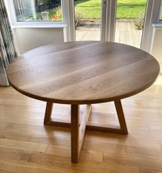 a wooden table sitting on top of a hard wood floor next to a sliding glass door