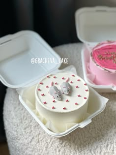 two small cakes in plastic containers on a table