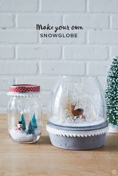 two snow globes sitting on top of a wooden table