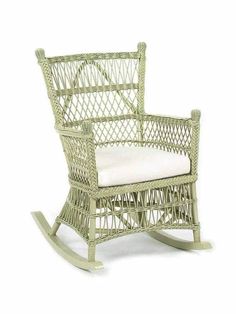 a wicker rocking chair with white cushions