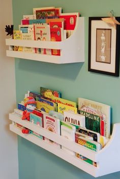 two white shelves holding books in a child's room with blue walls and green paint