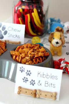 there are many dog treats on the table with their name tags in front of them