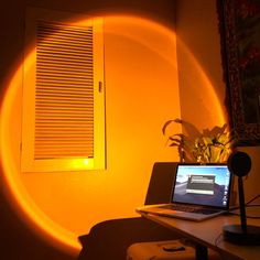 a laptop computer sitting on top of a desk under a light that is shining down