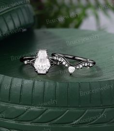 two wedding rings sitting on top of a green tire treading surface with greenery in the background