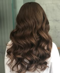 the back of a woman's head with long, wavy hair