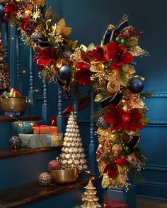 christmas decorations on the stairs in a blue room with red and gold ornaments around them