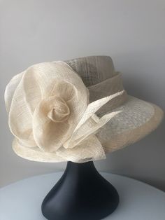 Truly elegant customized handmade high quality 3 layered cream sinamay hat. It may be fitted with a black headband which is easy to hide in your hair if you desired. It is incredibly flattering and easy to wear, strong, light, and comfortable. The hat is ideal to wear to the Kentucky Derby, Royal ascot, any horse racing venue, garden parties, social occasion, easter, weddings including as an accent piece for bridesmaid and mother of bride/groom, church wear, and special events. We make a range o Cream Hat, Hat Tea Party, Sinamay Hat, Tee Party, Sinamay Hats, Hat Wedding, Hat Fascinator, Tea Party Hats, Wedding Hat