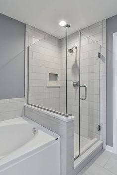 a white bath tub sitting next to a walk in shower