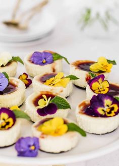 small desserts with edible flowers are arranged on a white plate, ready to be eaten