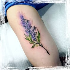 a woman's arm with purple flowers and green leaves on the left side of her body