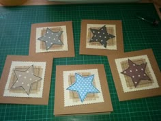 four star shaped pictures are sitting on a cutting board next to some scissors and thread