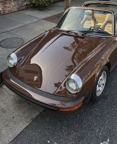 a brown sports car parked on the side of the road