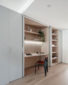 an office with shelves, desk and chair in the middle of the room that is partially open