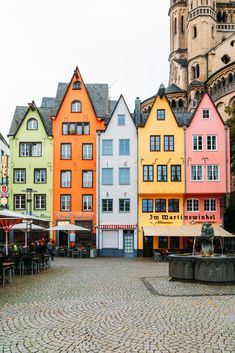 many colorful buildings line the street in front of a building with a clock tower on top