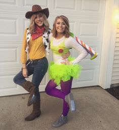 two women dressed in costumes standing next to each other near a garage door with their hands on their hipss