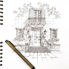 a pen is sitting next to a drawing of a house with flowers on the porch