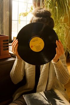 a woman holding up a record in front of her face