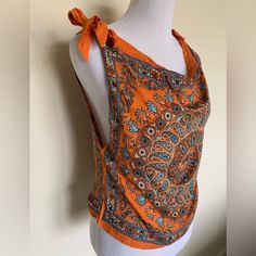 an orange and blue top on a mannequin's torso with a bow at the neck