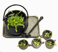 a pot filled with green beans sitting on top of a pan next to four smaller pots