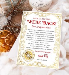 a christmas card with an elf's message on it next to some pine cones