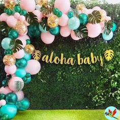 the balloon arch is decorated with tropical leaves and balloons for a baby's first birthday