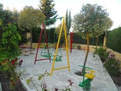 an outdoor play area with swings and flowers