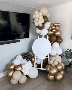 there are many balloons in the room and one is white, gold and brown colors