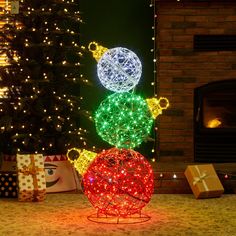 a lighted christmas decoration in front of a fireplace