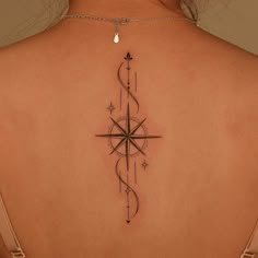 a woman's back with a compass tattoo on it