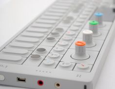 an electronic device with buttons on it sitting on a white table next to a keyboard