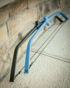 a pair of blue and black bicycle bars leaning against a brick wall on the sidewalk