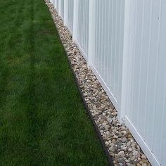 a white fence with green grass next to it