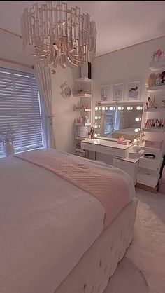 a bedroom with a chandelier hanging from the ceiling and a white bed in front of a window