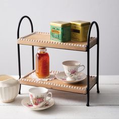 two tiered trays with tea cups and saucers on them, one holding honey