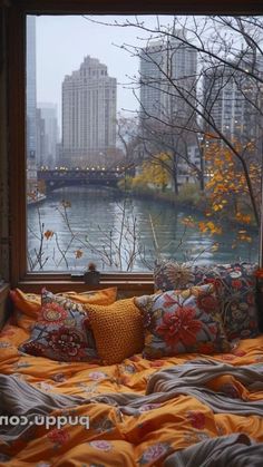 a bed sitting in front of a window next to a tree with no leaves on it